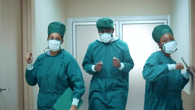Happy African American team of doctors, nurses and assistants dances while walk through the corridors of hospital. medical personnel having enjoy.
