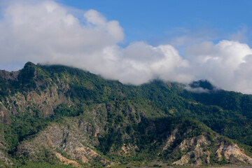 Fototapeta na wymiar The rugged mountains covered in clouds on tropical Atauro Island in Dili, East Timor, on the extinct Wetar segment of the volcanic Inner Banda Arc