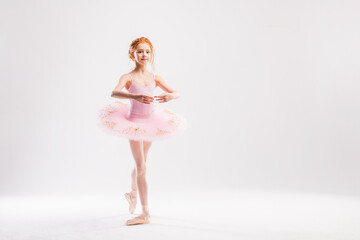 Little ballerina dancer in a pink tutu academy student posing on a white background © Maria Moroz