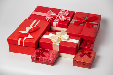 Red and striped boxes with gifts tied bows on white background