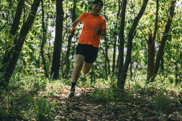 Woman runner running on forest trail