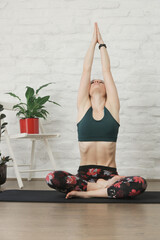Young woman practicing meditation and breathing exercises. Wellbeing and self care concept.