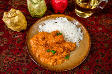 Chicken tikka masala with rice on plate, 3 bamboo spice box, cup of tea.