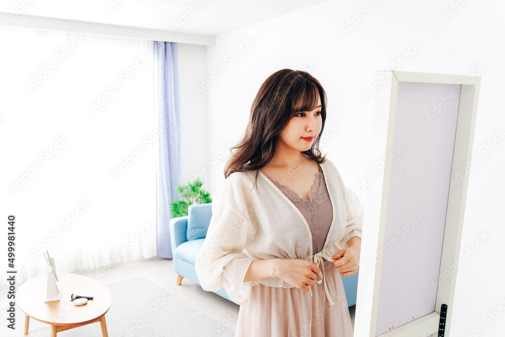 Wall mural Young woman changing clothes at home