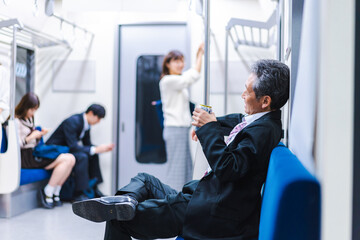 Middle-aged man drinking on the train - obrazy, fototapety, plakaty