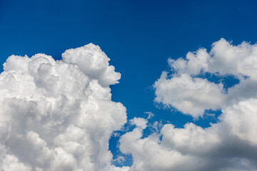 Naklejka na ściany i meble Beautiful storm clouds, cumulus clouds or cumulonimbus against a clear blue sky. Photography, Full frame.