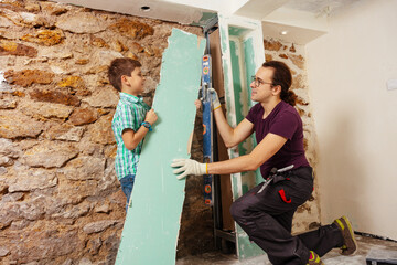 Dad with a boy holding level doing renovation at home