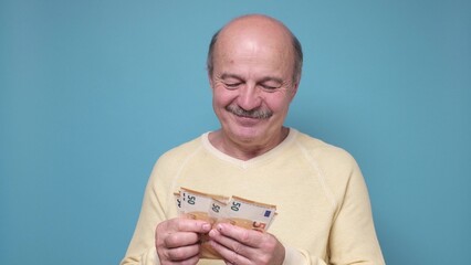 Male pensioner counting money isolated on white background