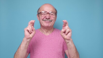 Adult man smiling crossing fingers with hope.
