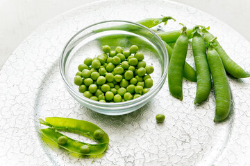 Green peas in a glass cup on a silver tray