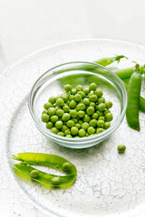 Green peas in a glass cup on a silver tray