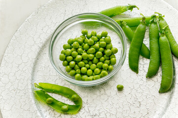 Green peas in a glass cup on a silver tray