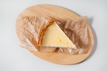 Sweet cheese cake on wooden board top view.
