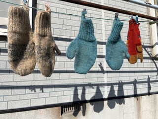 Woollen mittens hanging outdoors on a clothes line