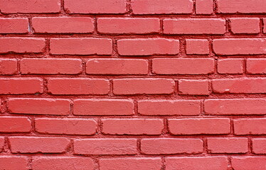 Old red brick wall painted with fresh paint. Brickwork with uneven seams texture of the design background in the loft style.