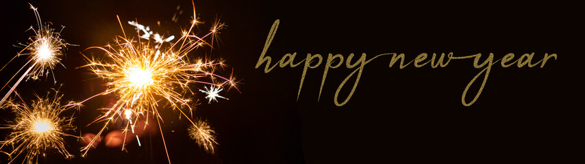 Happy New year 2023 background banner panorama - People hold sparkling sparkler in her hand at dark...