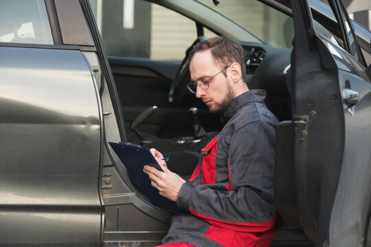 The Mechanic Checks The Door And Checks The VIN Code Of The Car, Makes Notes