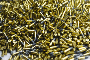 Small-caliber bullets on white table at production plant