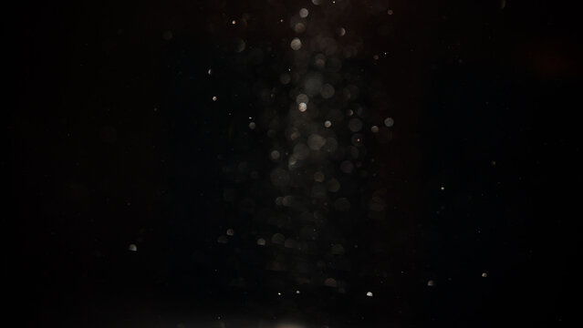 Shot of real dust particles floating in the air on the dark background. Dust Particles Background