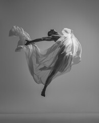 Liberty. Black and white portrait of graceful muscled male ballet dancer dancing with fabric, cloth...