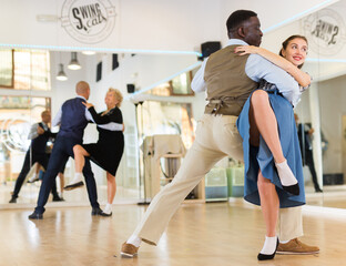 Woman and man dancing waltz in studio