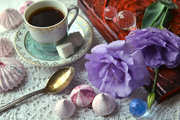 Obraz na płótnie Canvas Greeting card with blooming flowers of eustoma rose of lavender color, cup of coffee, vintage spoon, dessert and decorations.