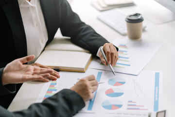 Two business people meeting to analyze investment and marketing on the desk in the office.