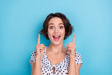 Portrait of funky crazy girl open mouth direct fingers up empty space isolated on blue color background