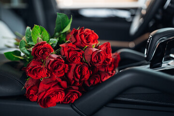 Flowers inside of modern luxury car interior. Beautiful bouquet at the leather modern car seats