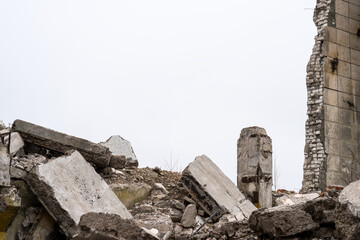 Gray debris of the building in the form of large concrete piles, slabs, beams with remnants of a...