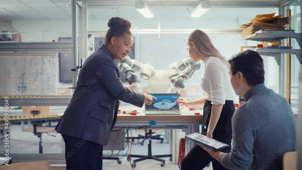 Aufkleber chief female engineer explains workings of robot arm to a group of young specialists. professionals 