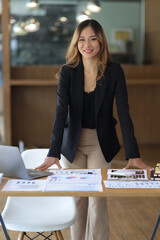 Portrait of a charming Asian businesswoman or manager at her desk in the office. Beautiful...