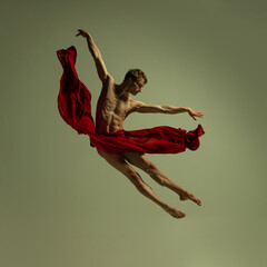 One young muscled man, flexible ballet dancer in action with red fabric, cloth isolated on olive color background. Theater, emotions, grace, art, beauty concept. - obrazy, fototapety, plakaty