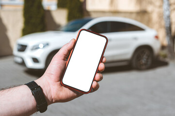 Mockup of a smartphone in a man's hand on the background of the car.
