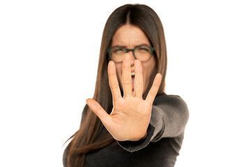 Angry screaming woman making stop gesture with her hand on a white background