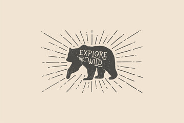 Hand drawn bear with an inscription explore the wild nature in the rays of light. Vintage label. Wildlife. Monochrome style. Vector illustration on dark background.