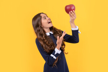 inspired kid holding red vitamin apple for lunch on yellow background, detox