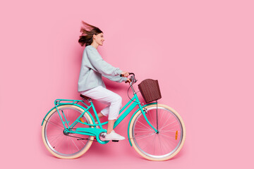 Full size profile side photo of young pretty girl carefree drive bicycle vehicle look empty space...
