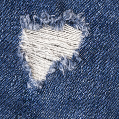 Fototapeta na wymiar Torn blue jeans with hole material texture, close-up
