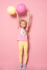 Fototapeta na wymiar Pretty little girl with colorful balloons on pink background