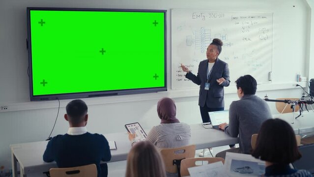 Black Female Teacher Explains Lesson to Students, Uses Green Screen Digital Whiteboard. Successful Woman Talks about Design. Science and Education Concept