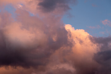 Colorful clouds in orange and purple colors against blue sky during sunset, detail from atmosphere