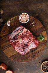 Raw fresh meat Ribeye Steak, seasoning and fresh tomato on wooden background