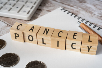 キャンセルポリシーのイメージ｜「CANCEL POLICY」と書かれた積み木、電卓、コイン、ペン