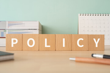 ポリシーのイメージ｜「POLICY」と書かれた積み木が置かれたデスク