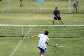 Amateur playing tennis at a tournament and match on grass in Melbourne, Australia 