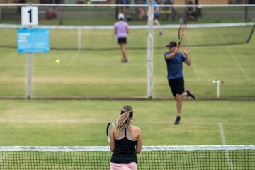 Amateur playing tennis at a tournament and match on grass in Melbourne, Australia 