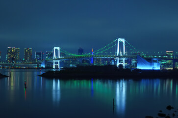 Fototapeta na wymiar 東京都お台場から見る緑の電飾のレインボーブリッジと東京タワーの夜景