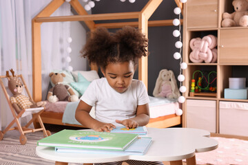 African American girl reading book at home