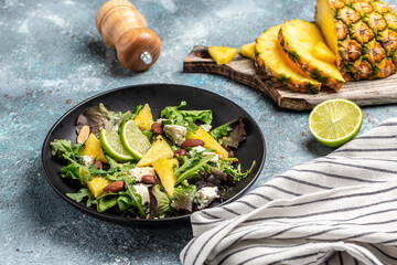 Pineapple Salad with greens blue cheese and almond, Healthy food clean eating selection. Food recipe background. Close up